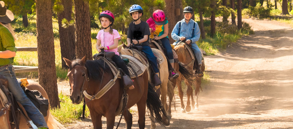 Youth riding horses with instructor
